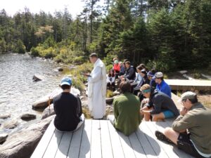 Idosos recebem a Santa Missa com vista para o Lago Solitário em Franconia Notch
